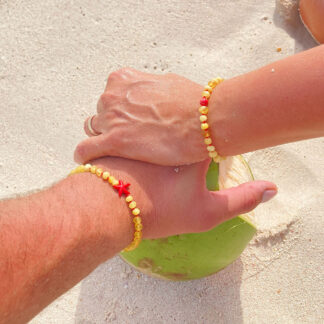 Brățări din chihlimbar cu stea, purtate de cuplu pe plajă