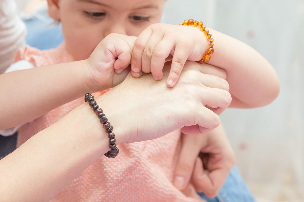 Mama si fiica purtand impreuna bratari din chihlimbar